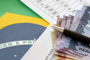 Pen With Brazilian Money Bills On Blank Of Lottery Game. Concept Of Luck And Gambling In Brazil Focus Contabilidade - MP Contabilidade